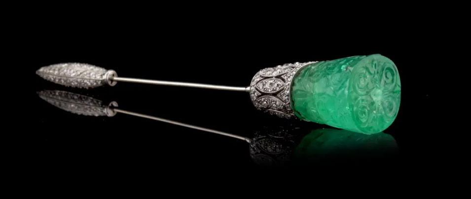 A chic platinum carved emerald and diamond jabot pin by Cartier